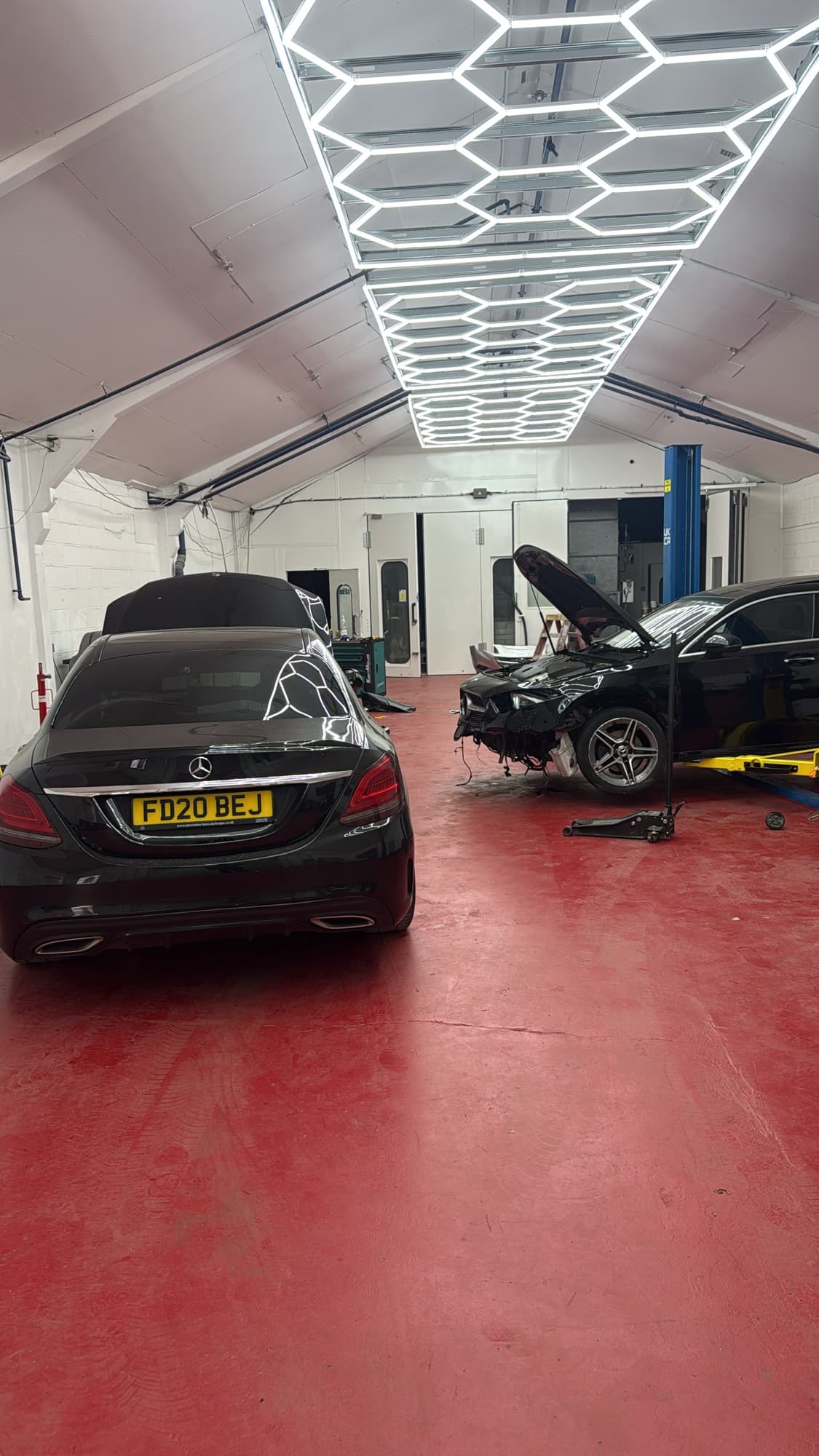 Mercedes E-Class crash repair in progress beside another saloon