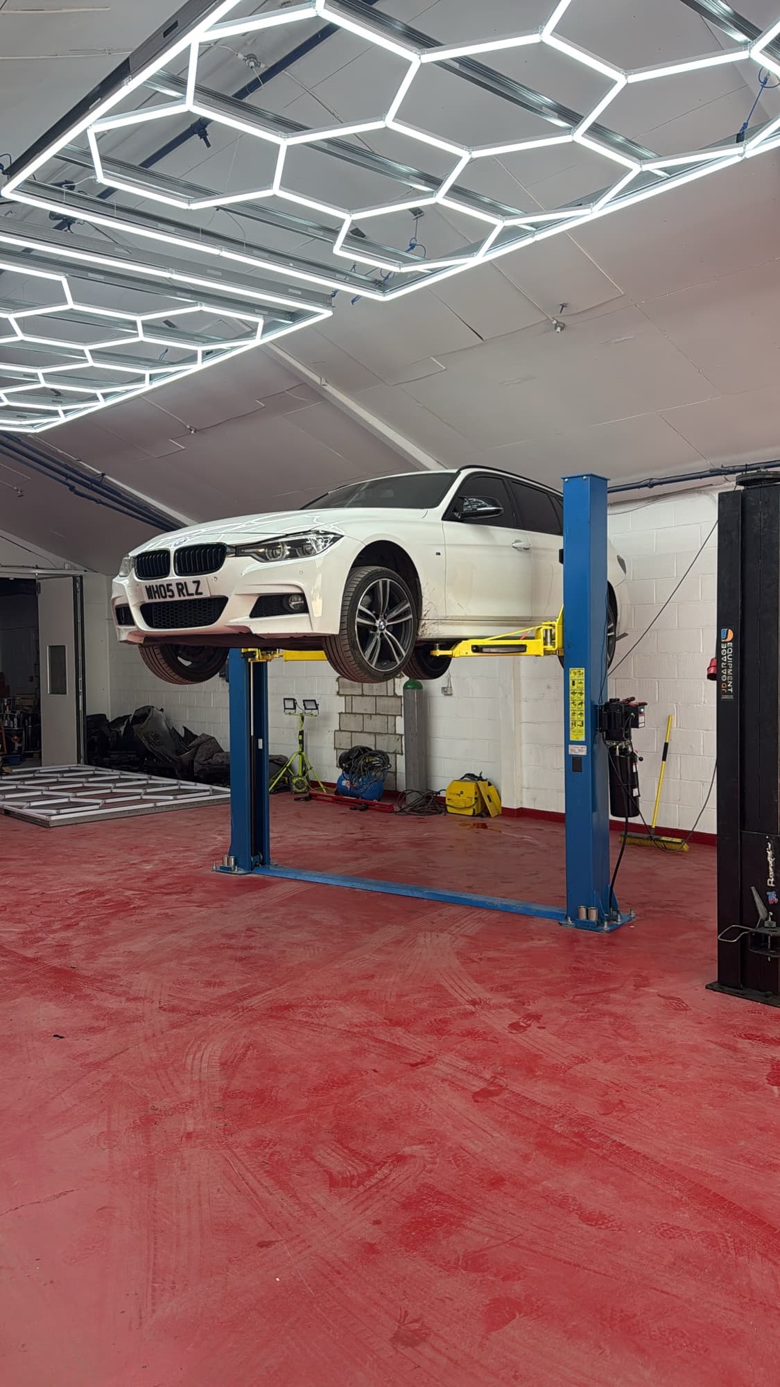 White BMW 3 Series on a two-post lift in the LRC Autoworks workshop